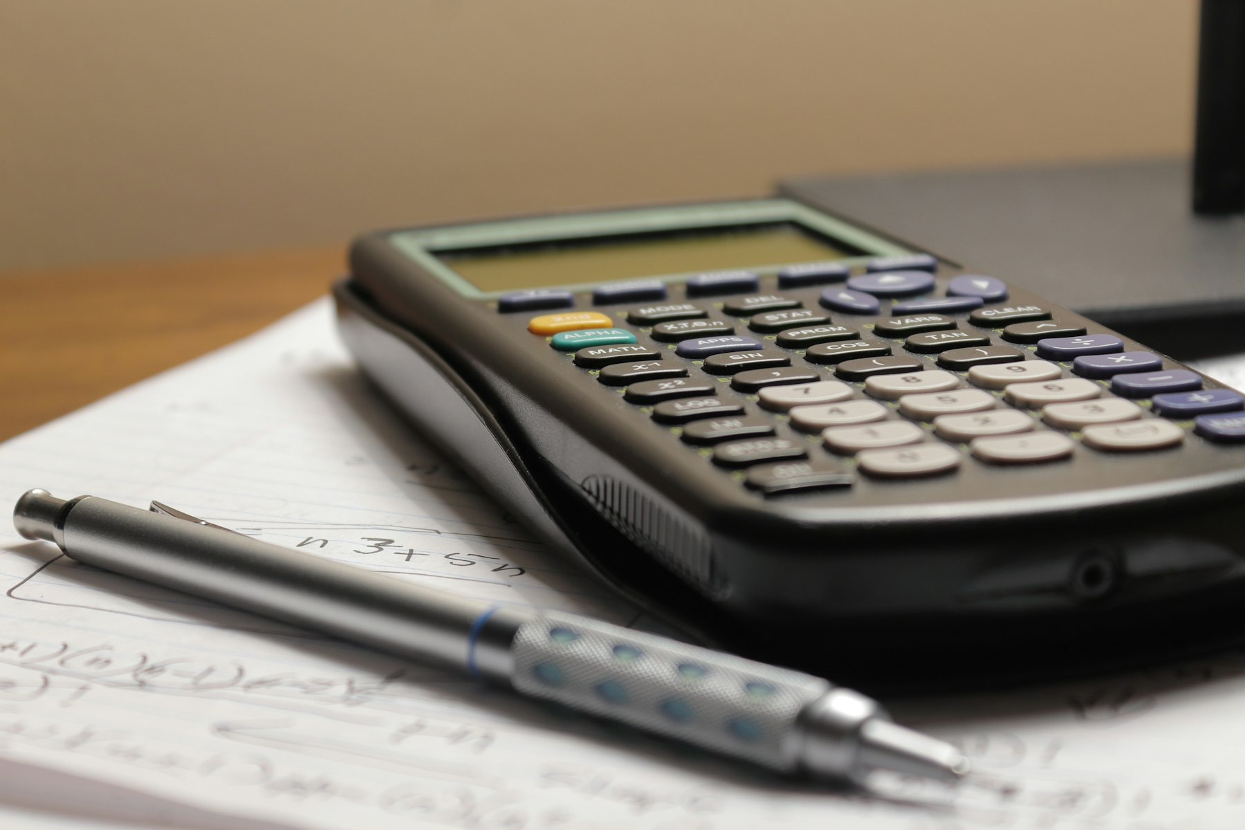 Calculator and pen on handwritten paperwork