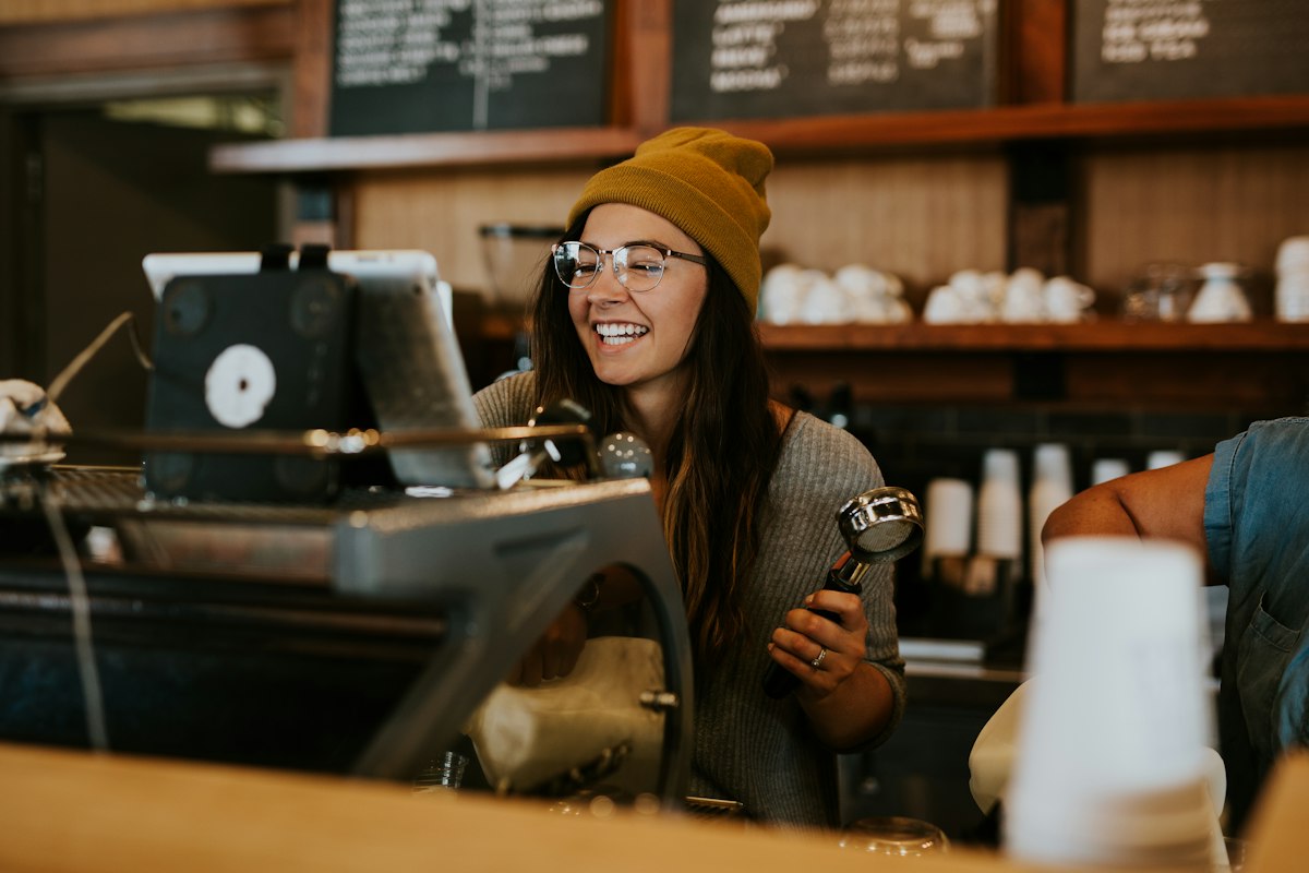 Smiling barista behind a café counter
